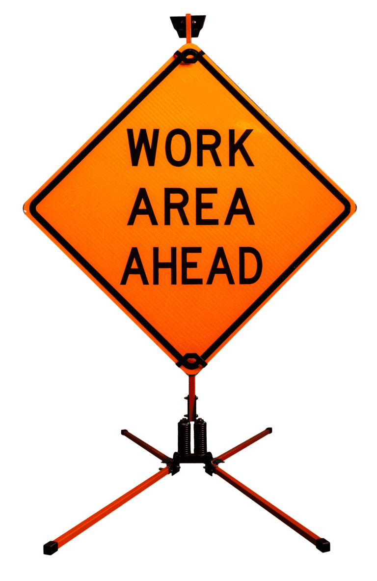 An orange diamond-shaped sign reads WORK AREA AHEAD, mounted on a portable metal stand with four legs, indicating construction or maintenance ahead.
