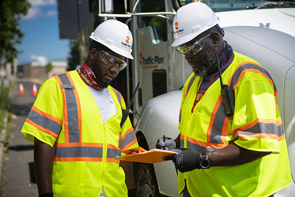 traffic plan crew members discussing notes while standing next to large company vehicle