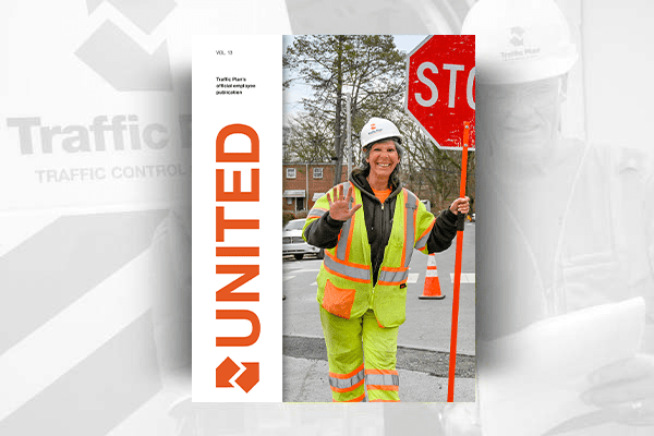 A smiling construction worker in high-visibility clothing holds a stop sign and waves, featured on the cover of a magazine titled UNITED. Traffic cones and trees are visible in the background.