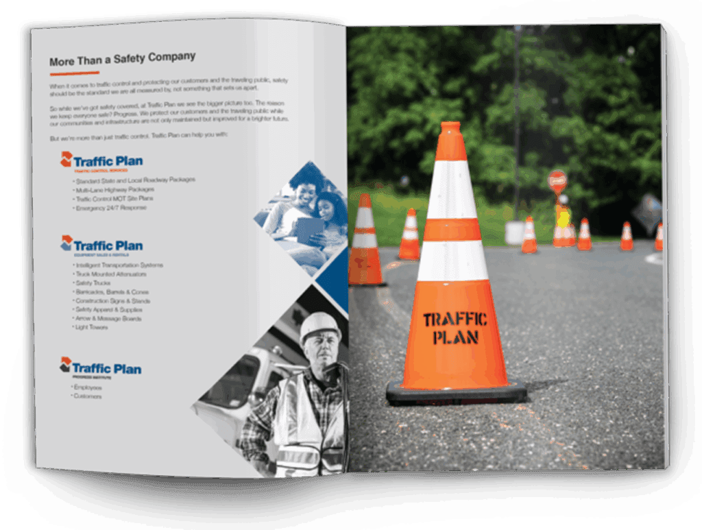 An open brochure displays safety information and images. The left page lists traffic plans and includes photos of safety workers and families. The right page shows an orange traffic cone labeled “TRAFFIC PLAN” on a road with more cones in the background.