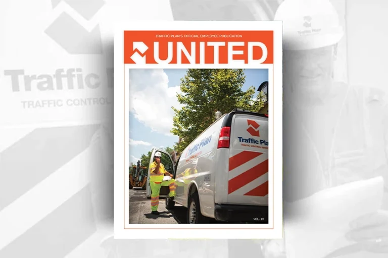A traffic control worker in a yellow vest stands beside a white Traffic Plan van with orange stripes, under a sunny sky, featured on the cover of the 20th volume of the Traffic Plan publication, UNITED.