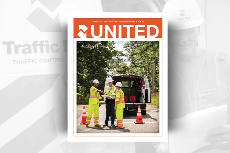 Three construction workers in safety gear stand by an open van and traffic cones, discussing plans. The magazine cover reads UNITED in bold orange letters at the top. Trees and road are visible in the background.